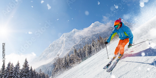Skier skiing downhill in high mountains