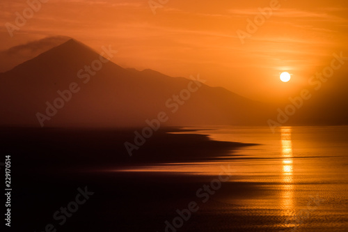 Sunset tropical beach landscape with silhouette of hills in Fuerteventura.