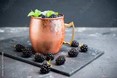 Photography Blackberry moscow mule in copper mug on the rustic background