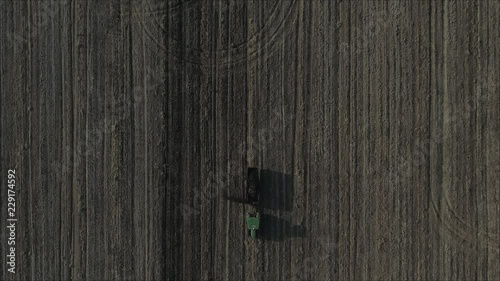 Aerial shot of Farmer with a tractor on the agricultural field sowing. tractors working on the agricultural field in Italy