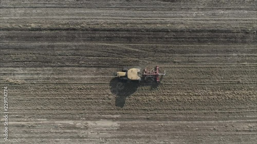 Aerial shot of Farmer with a tractor on the agricultural field sowing. tractors working on the agricultural field in Italy