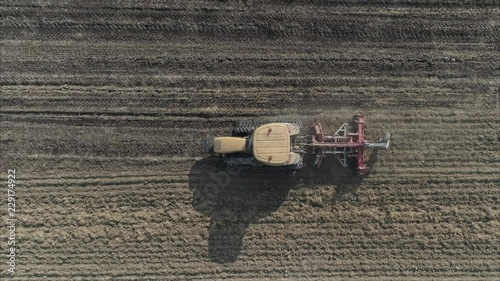 Aerial shot of Farmer with a tractor on the agricultural field sowing. tractors working on the agricultural field in Italy