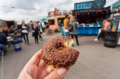 Photography Street food and donut in hand of visitor of the fast-food market of Copenhagen, Denmark