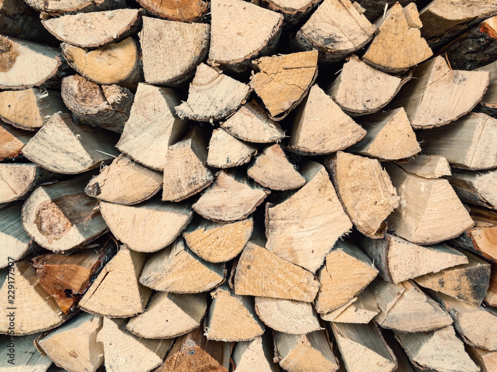 Chopped aspen firewood stacked in woodpile, texture