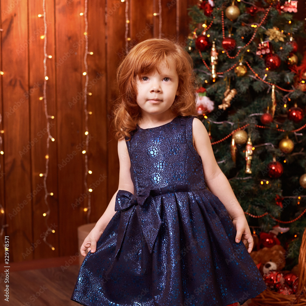 Portrait little girl. New Year xmas child. Christmas eve holiday. interior. Blue dress