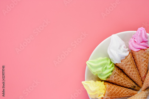 White plate of various of ice cream cone on pink background for sweet and refreshing dessert concept
