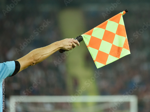 Raised hand with flag of assistant soccer referee