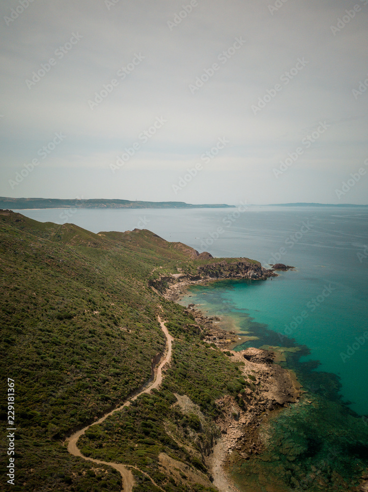 Beach landscape. Emerald green sea water and rocks on coast of Sardinia, Italy.