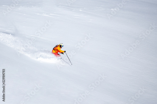 One skier skiing downhill through fresh powder snow, no sky, white snow background