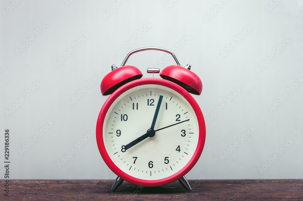Red alarm clock on a wooden table. Red alarm clock on a wooden table.