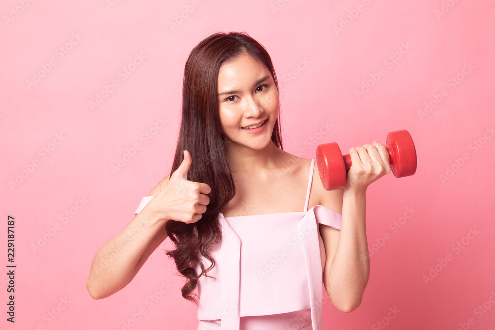 Healthy Asian woman thumbs up with dumbbells. Healthy Asian woman thumbs up with dumbbells.