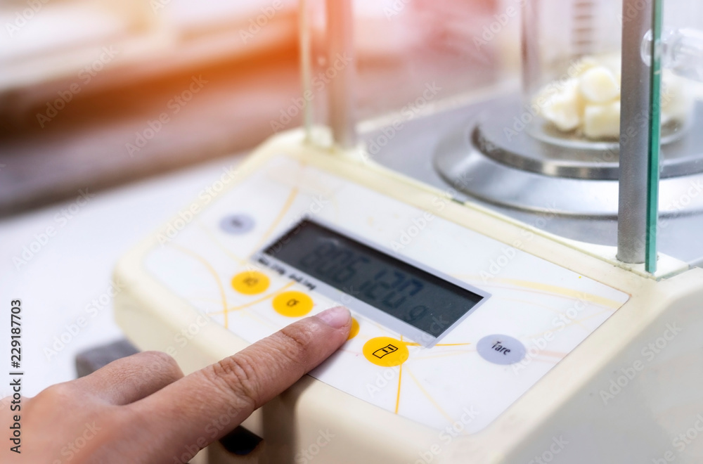 Scientist is weighing the sample with electronic weighing scales