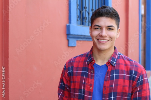 Handsome young hispanic male smiling outdoors