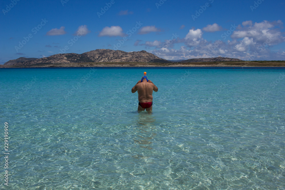  Swim, diving man. Beautiful panorama with the Mediterranean sea in Sardinia, Italy. crystal and colorful water. Beautiful sky. Travel life.