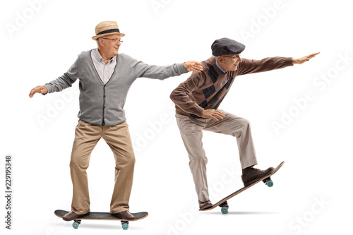 Two elderly men skateboarding photo