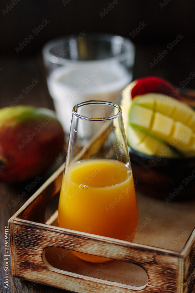Glass with fresh mango juice in wooden box Glass with fresh mango juice in wooden box