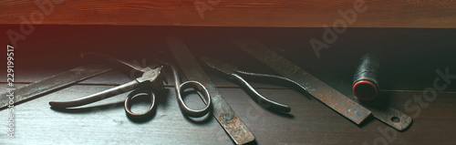 Shoemaker's work desk. Old tools on wooden table. Shoemaker's shop. Instruments at cobbler workplace. Vintage style. Shoes maker tools.