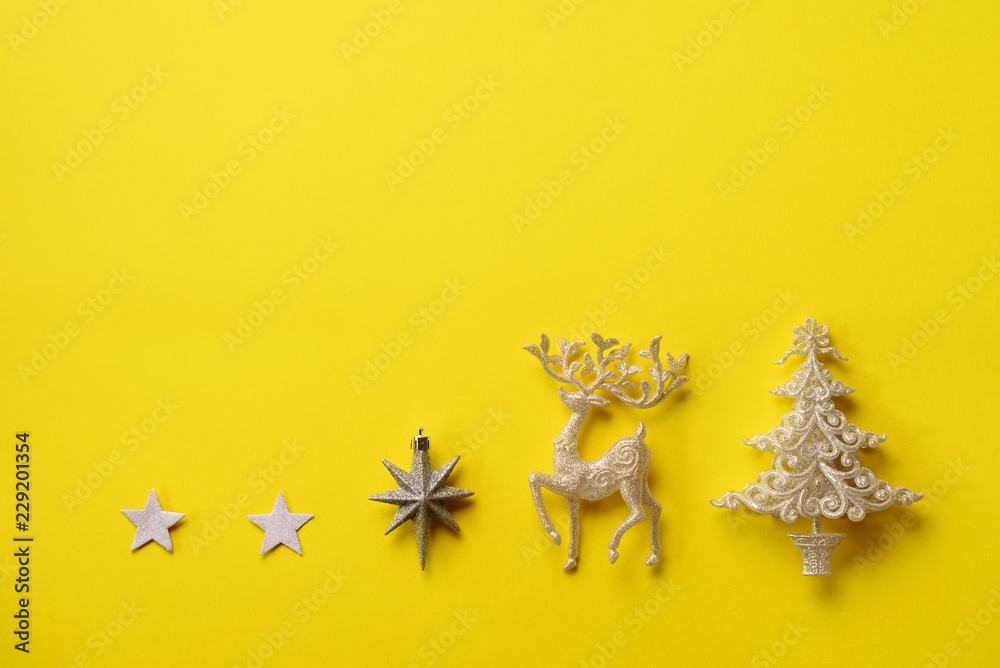 Festive silver dear, stars, fir-tree, cone on yellow background with copy space. Christmas and new year party. Minimal concept. Flat lay, top view