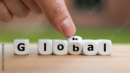 Hand is turning a dice and changes the word lokal to global