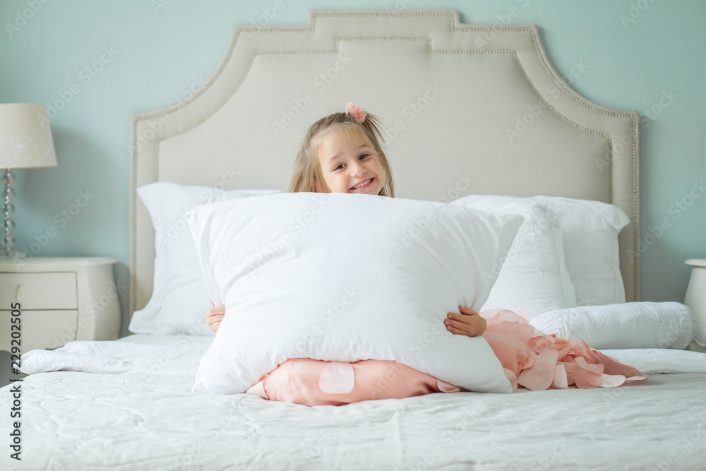 Happy child girl with white pillow at home Happy child girl with white pillow at home
