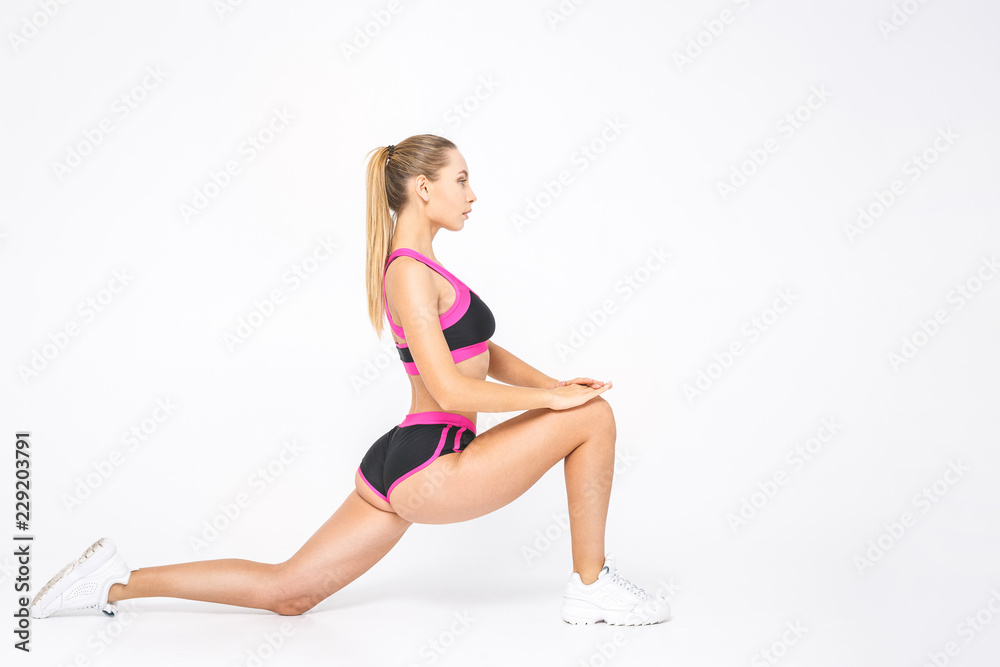 Great progress. Young beautiful woman in sportswear doing stretching isolated over white.