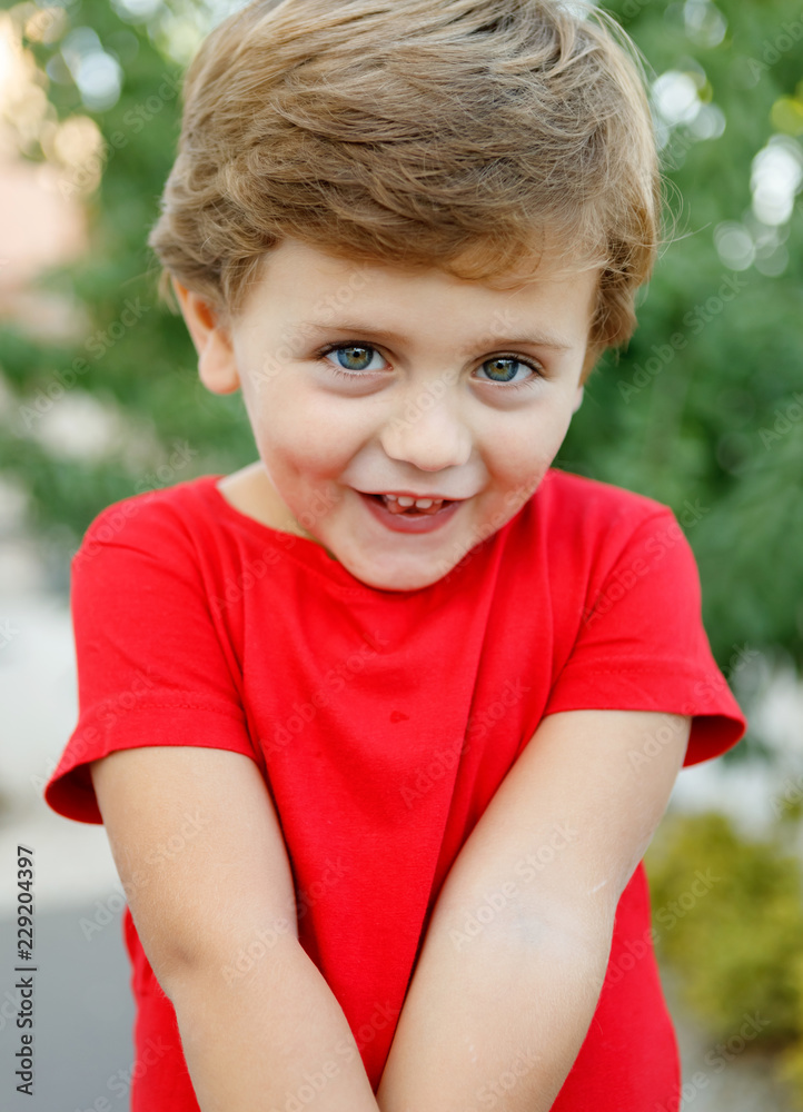 Happy child with red t-shirt in the garden Happy child with red t-shirt in the garden