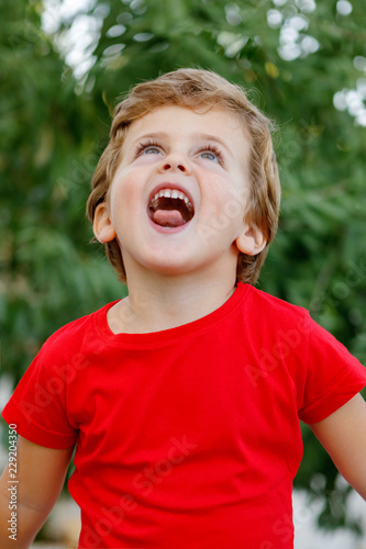 Happy child with red t-shirt in the garden