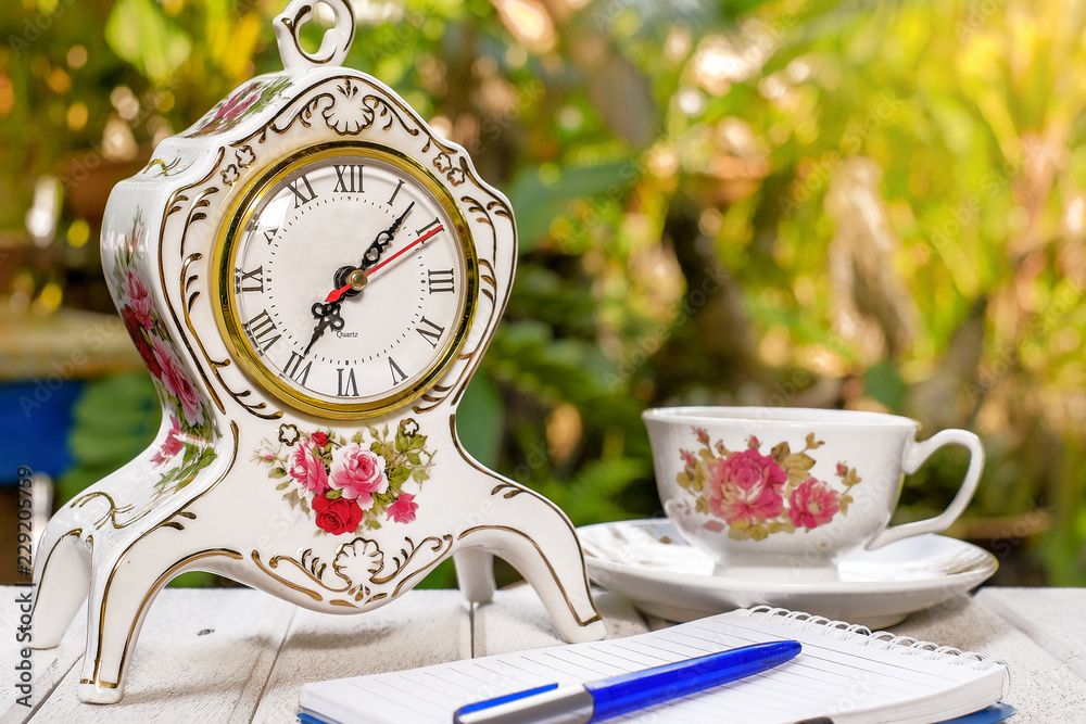 Cup of coffee, open notebook with blank pages, vintage clock, pen, on green background Still life, concept of business Cup of coffee, open notebook with blank pages, vintage clock, pen, on green background Still life, concept of business