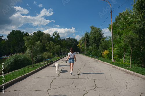 Back view woman walking her dog in the park photo