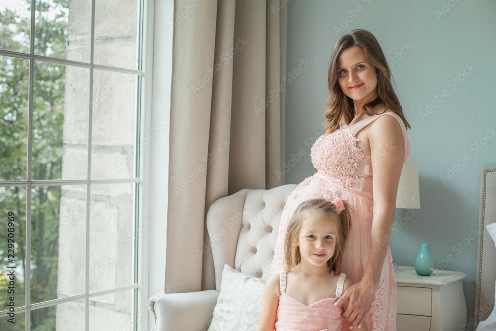 Happy mom and daughter. Pregnant woman and little child girl Happy mom and daughter. Pregnant woman and little child girl