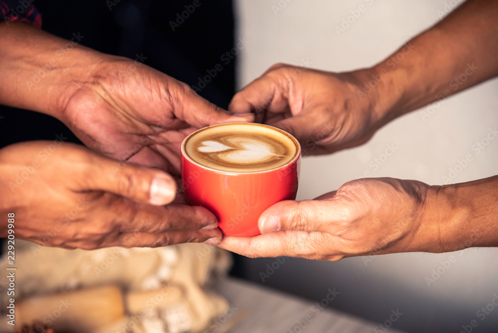 Barista's hands are delivering coffee to customers.