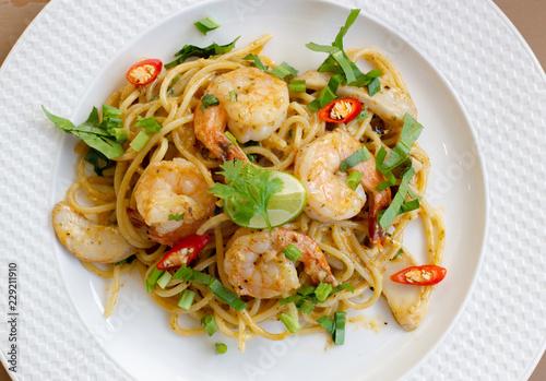 top view of delicious spaghetti seafood with shrimps, tomatoes, basil and cheese - italian food style