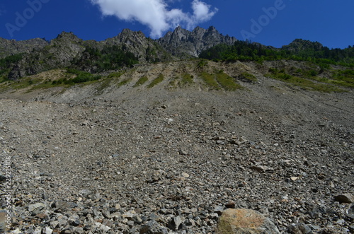 high mountain with rocks at the top and blue sky with clouds
