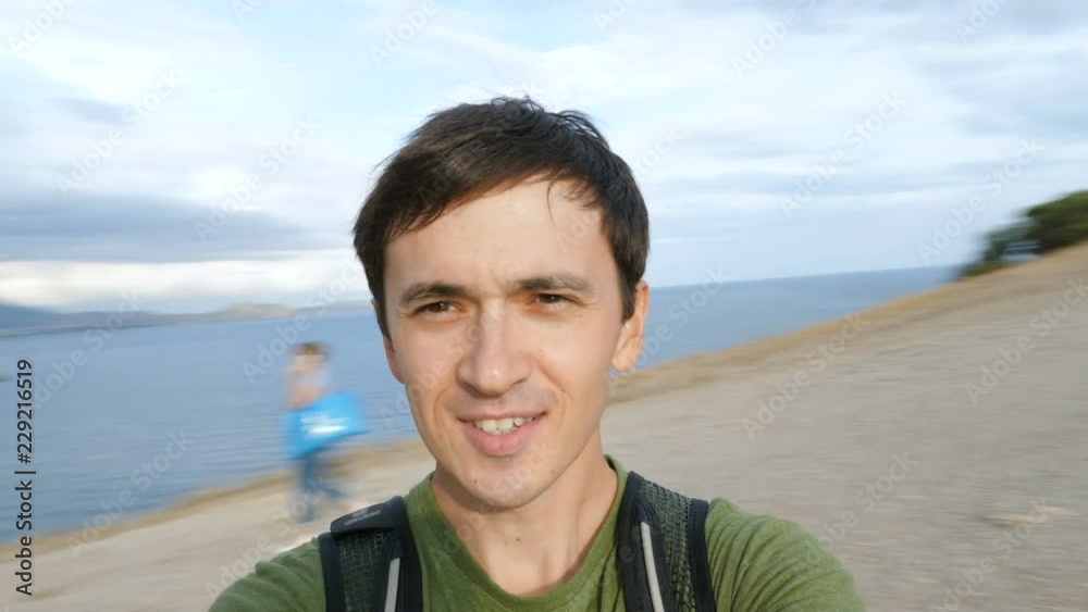 A young man makes a selfie video on nature, spinning around in a mountainous area near the sea. A young man makes a selfie video on nature, spinning around in a mountainous area near the sea.