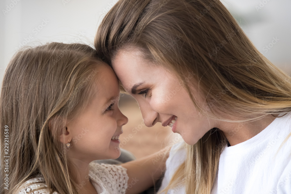 Loving mom and daughter embrace looking in eyes enjoying tender moment together, cute caring mother and child hug touching foreheads, having close strong connection. Bonding, family concept Loving mom and daughter embrace looking in eyes enjoying tender moment together, cute caring mother and child hug touching foreheads, having close strong connection. Bonding, family concept