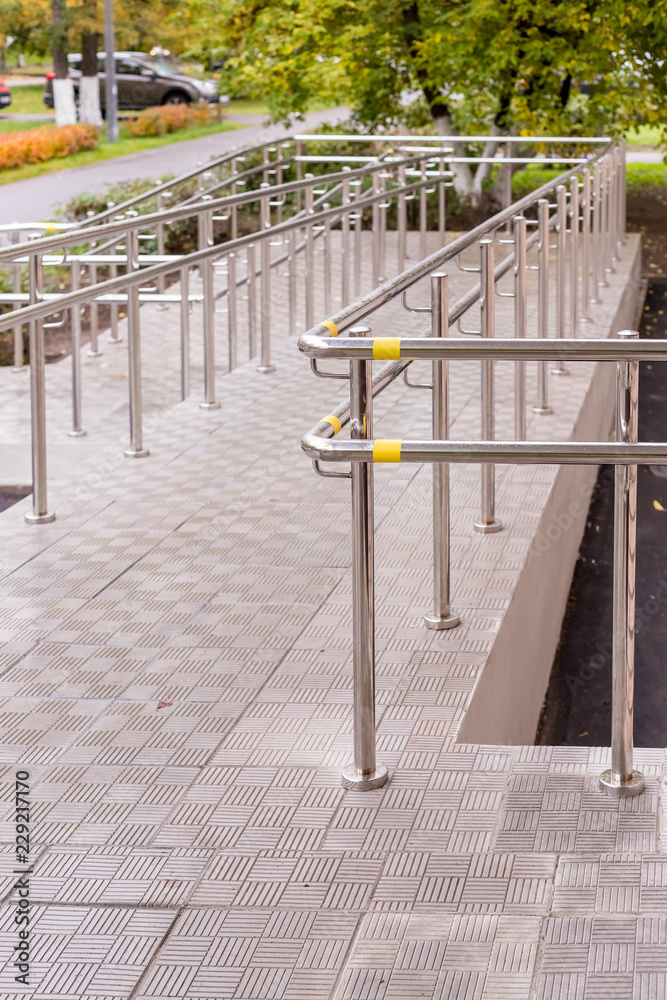 Concret ramp way with stainless steel handrail for support wheelchair disabled people. Health care concept. Copy space. Vertical image Concret ramp way with stainless steel handrail for support wheelchair disabled people. Health care concept. Copy space. Vertical image