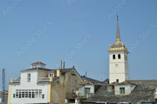 Bell Tower Of The Santiago Apostol Church And Houses With Very Old Roofs Practically Broken In Castropol. August 2, 2018. Architecture, Nature, Travel. Castropol, Asturias, Spain.