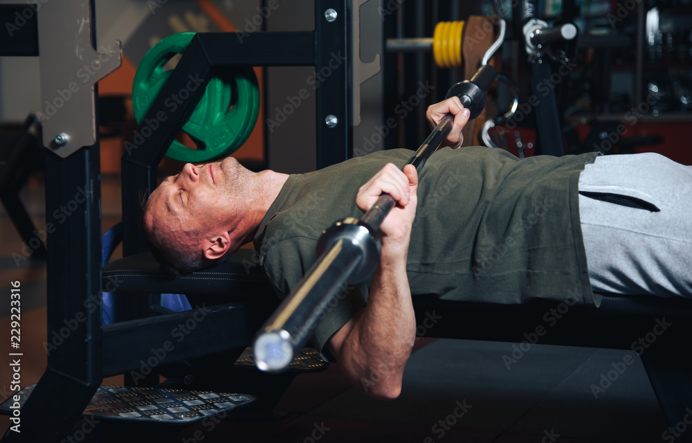 Tired man in the gym behind a fitness station.Fitness, sporting concept. Tired man in the gym behind a fitness station.Fitness, sporting concept.