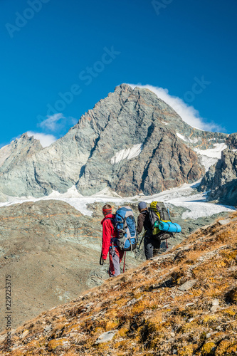 Two mountaineers watching Grossglockner peak in autumn, Austria