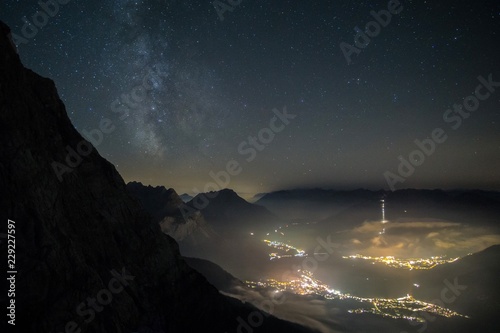 Milky way shot from high above, with the still illuminated city