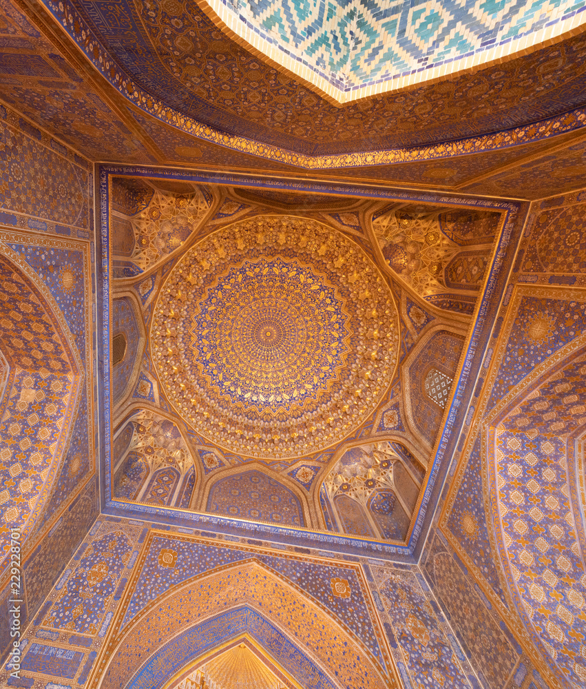 Blue interior of dome with gold gild of Tile Karl Madrasa in The Registan, Samarkand, Uzbekistan