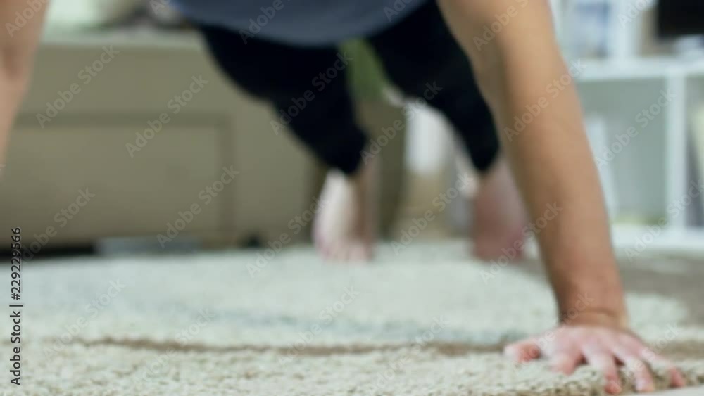 PAN of bearded young man in sportswear doing push-ups on floor of his apartment and looking at camera PAN of bearded young man in sportswear doing push-ups on floor of his apartment and looking at camera