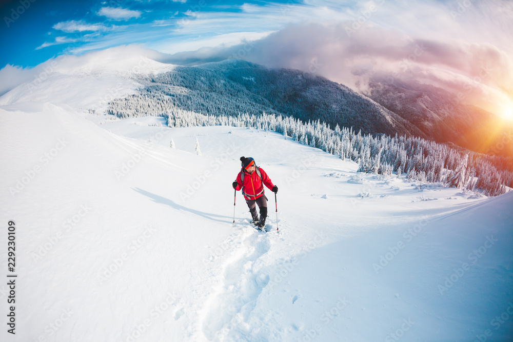 A man in snowshoes in the mountains. A man in snowshoes in the mountains.