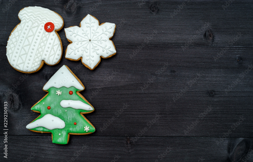 Christmas background with tasty homemade gingerbread cookies with icing on wooden table, top view, flat lay. Christmas tree, snowflake, mitten. Christmas food, copy space