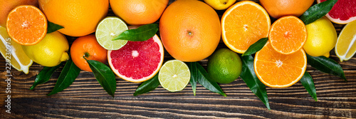 Fototapeta Naklejka Na Ścianę i Meble -  Fruits citrus background. Orange, grapefruit, lemon, lime, tangerine on dark wooden background. Long web format. Top view, flat lay