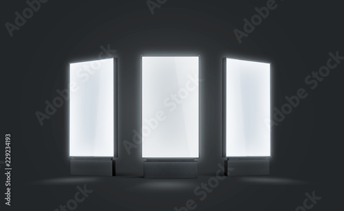 Blank white glowing pylon mock up set, isolated in darkness, 3d rendering. Empty illuminated screen mock up, different sides. Clear luminous poster for ad or affiche. Outdoor lightbox template.