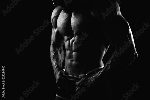 Muscular man's torso on black background with backlight Black and White photo