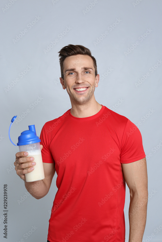 Portrait of man with bottle of protein shake on color background Portrait of man with bottle of protein shake on color background