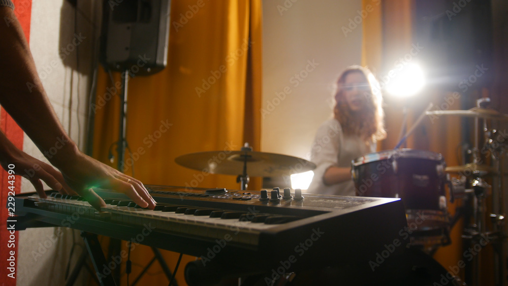 Repetition. Girl drummer and a guy on keyboards. Hands in focus Repetition. Girl drummer and a guy on keyboards. Hands in focus