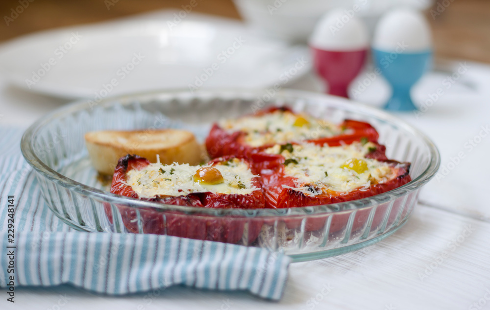 Stuffed red bright pepper with cheese, greens and quail egg in a glass bowl Stuffed red bright pepper with cheese, greens and quail egg in a glass bowl